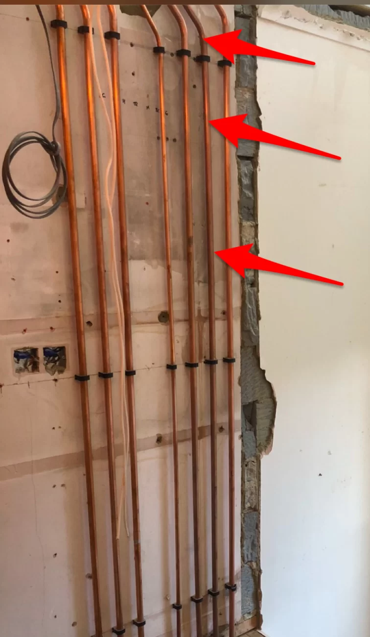 Pipe work behind freshly plastered wall - cold/damp spots please help.